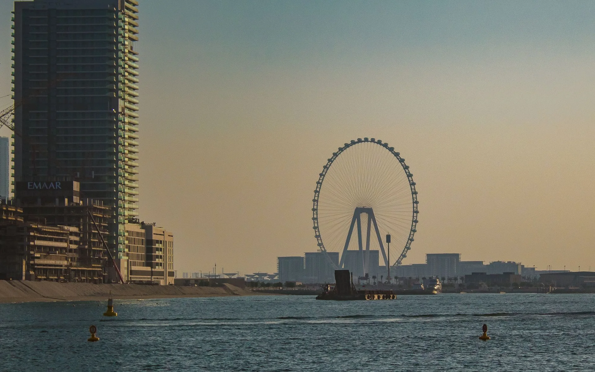 Panorama Dubaje s obřím kolem při západu slunce
