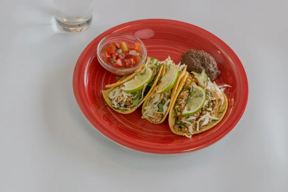 BookNoFees: Ukázková fotografie: Tři tacos zdobené plátky limetky se salsou na červeném talíři